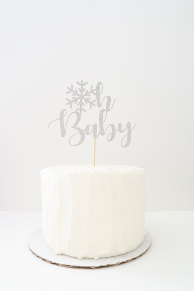 White cake with cake topper that says "Oh Baby" 