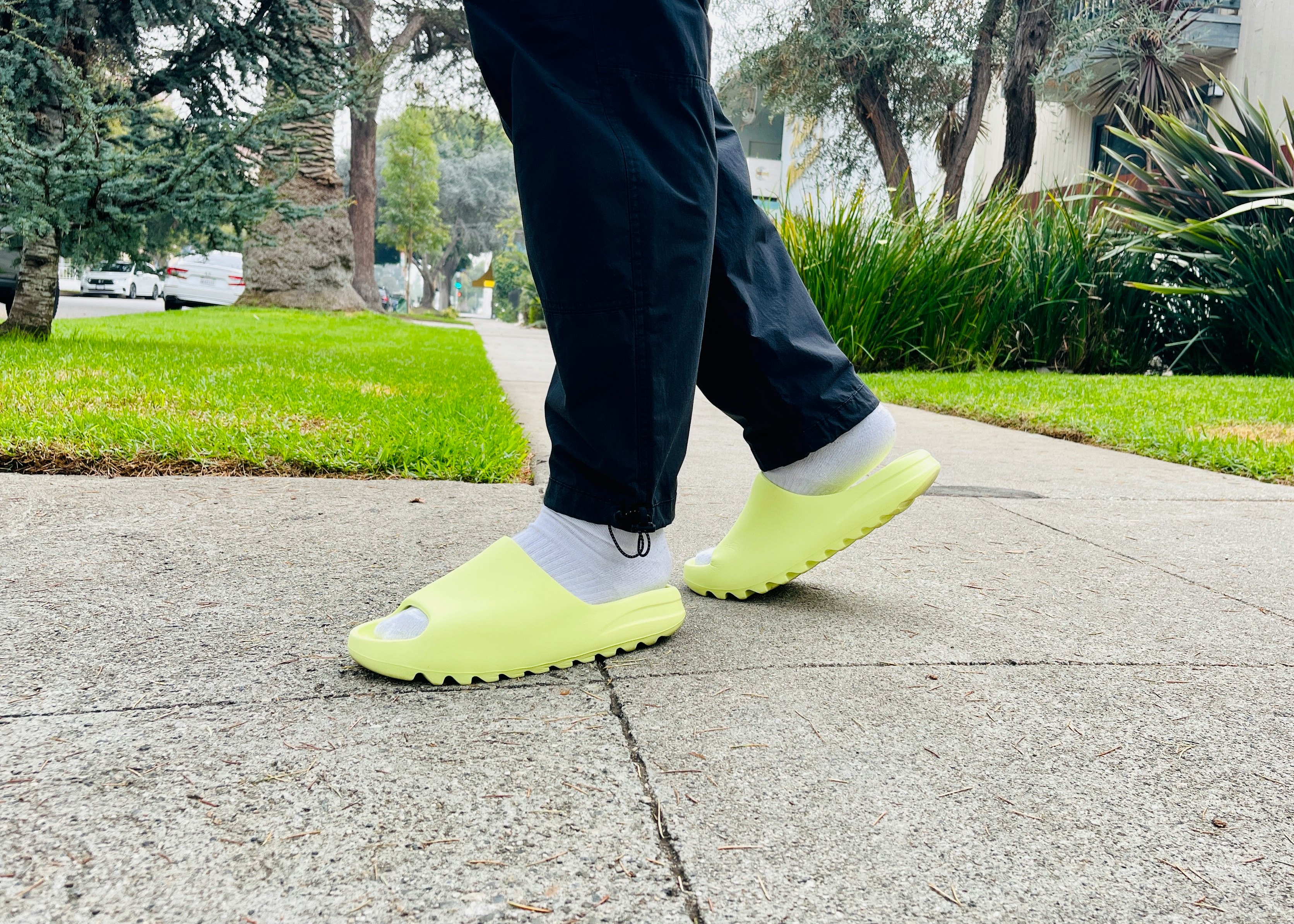 green yeezy slides on feet