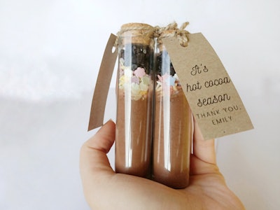 hand holding two test tubes filled with hot cocoa mix