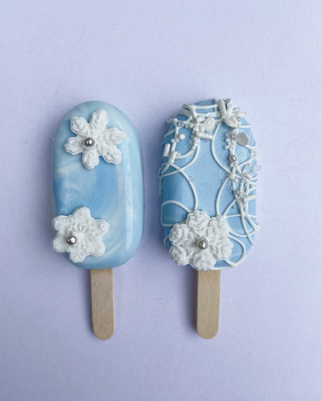 Two cakesicles, blue with snowflake designs