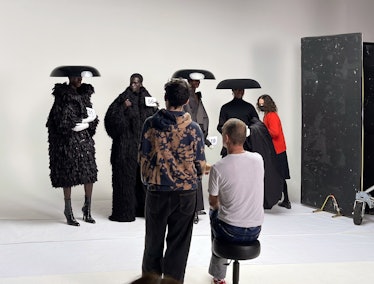 Editor in Chief Sara Moonves (far right, adjusting the drape of a coat held by model Seth Bedzo) sta...