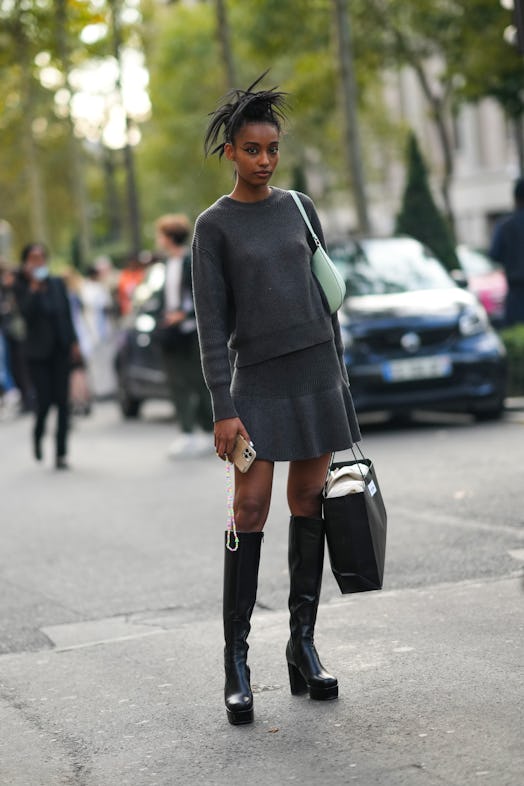 A guest wears a dark gray wool knit top and mini skirt.