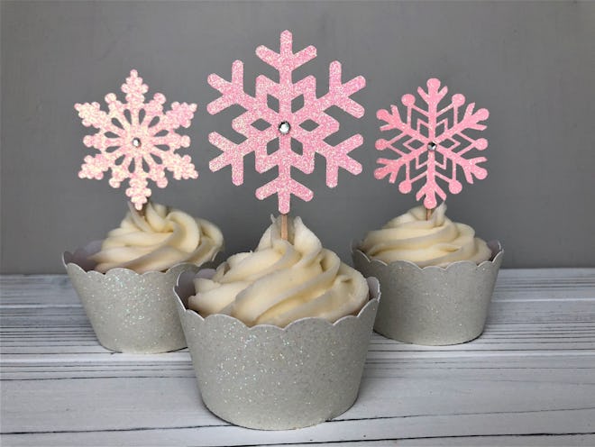 Three cupcakes with pink snowflake toppers