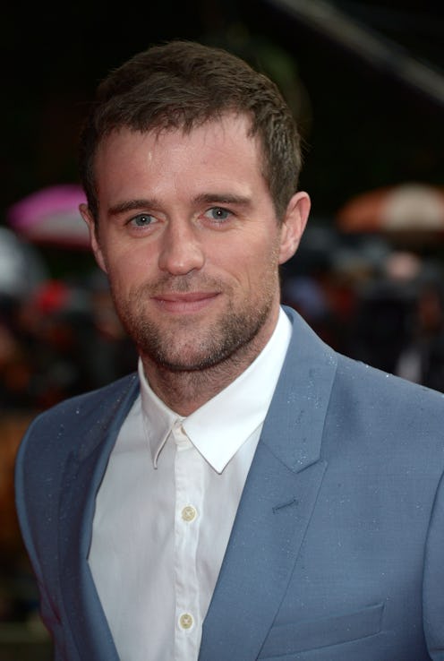 Jonas Armstrong from The Drowning at a red carpet event wearing a blue/grey suit and white shirt