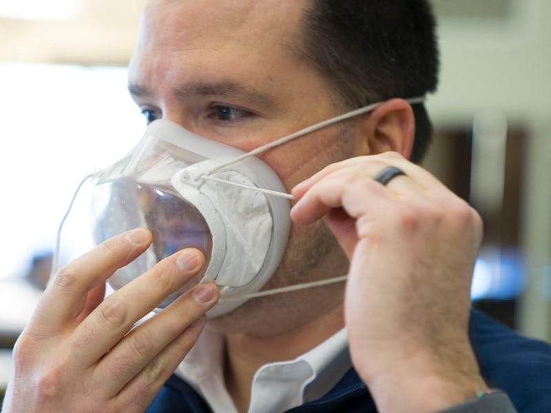 A man can be seen putting on a clear mask manufactured by Ford.