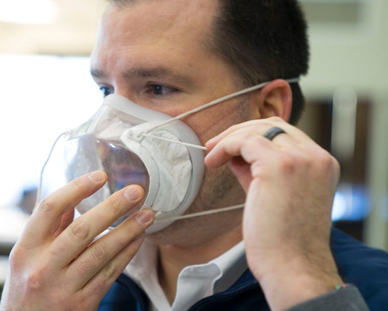 A man can be seen putting on a clear mask manufactured by Ford.