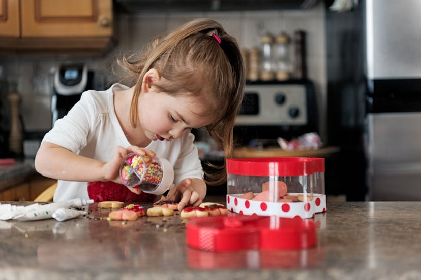 young girl making valentine's day cookies at kitchen counter
