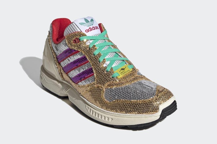 Sneaker covered in gold and silver sequins with green laces