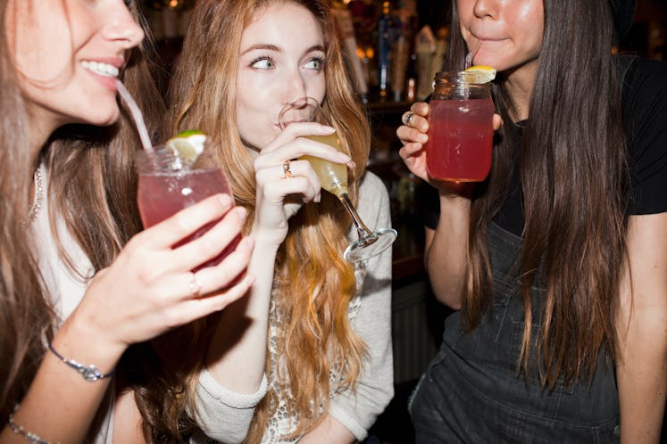 three young girls drinking at a bar
