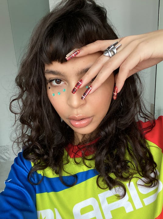 DJ Odalys showing off her long boxed nails and blue stickers under her eyes