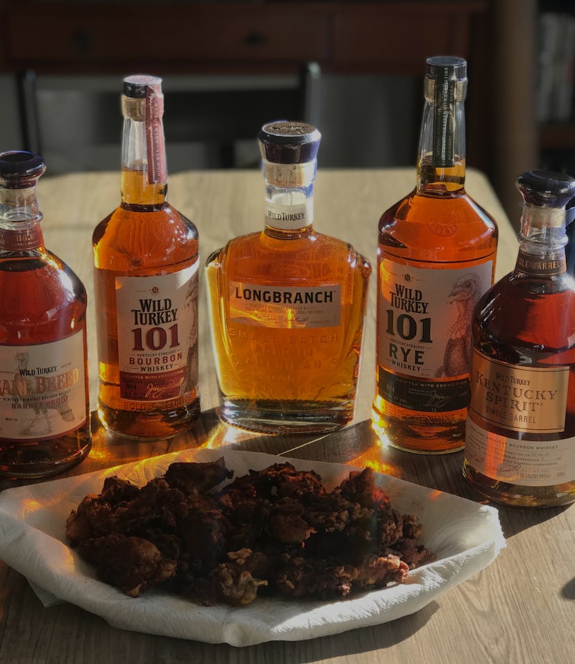 Five bottles of whiskey from the Wild Turkey Tasting company are shown on a dining table. There's a ...