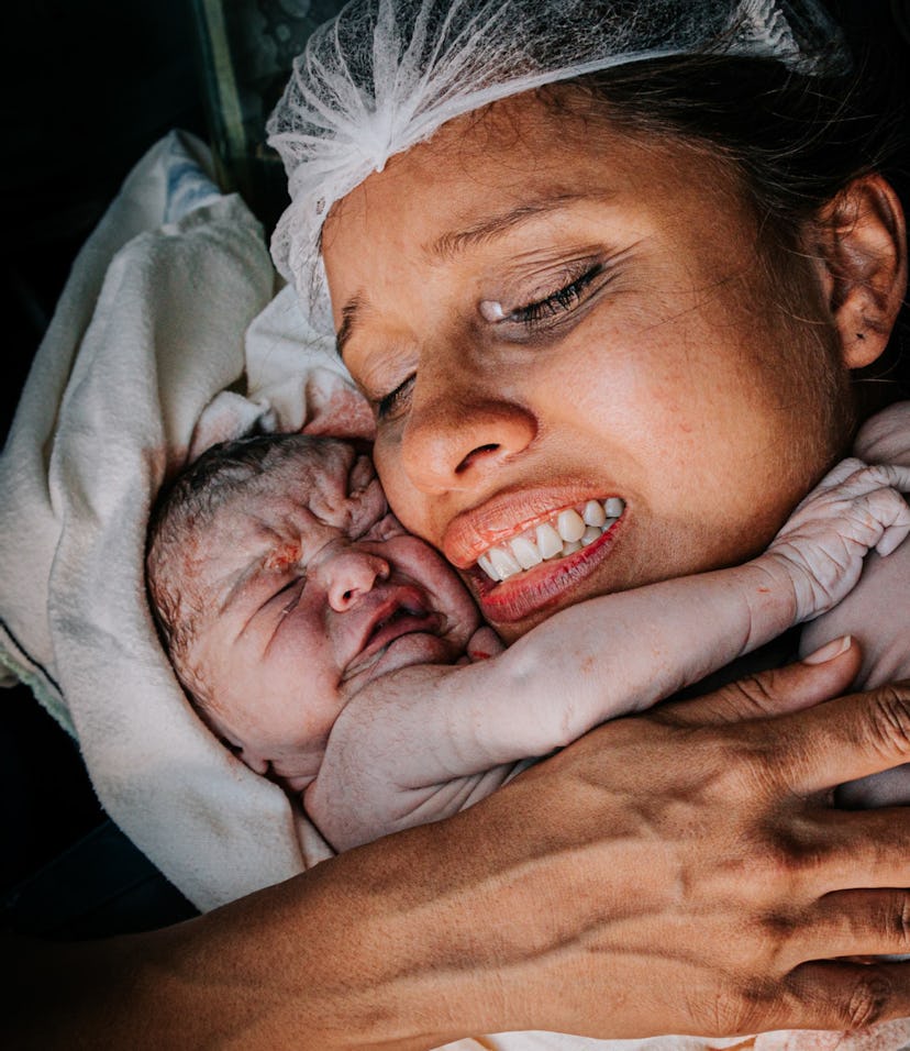 A woman cradles a newborn baby to her cheek in one of 26 award-winning birth photographs.