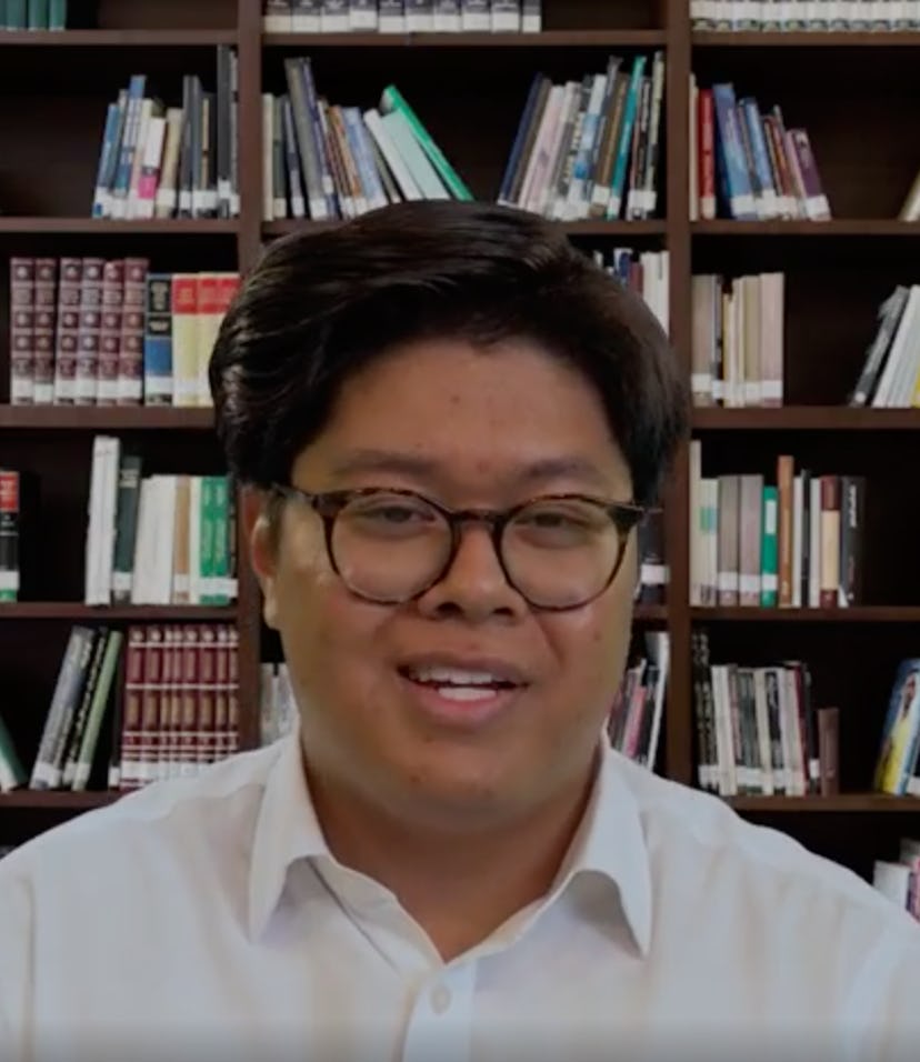 An Asian man sits in front a fake bookshelf background in BR's AI hiring experiment