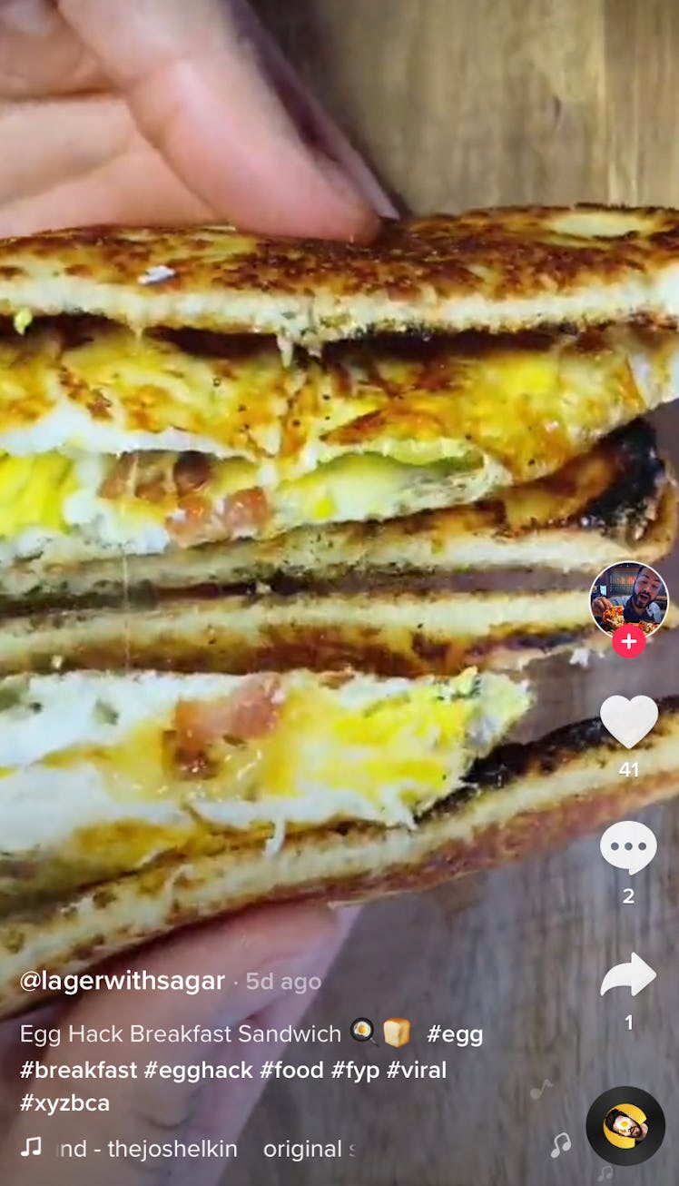 A man holds a egg hack breakfast sandwich from TikTok to show off the inside. 