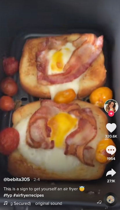 A woman cooks a bacon and egg open breakfast sandwich in her air fryer for TikTok. 