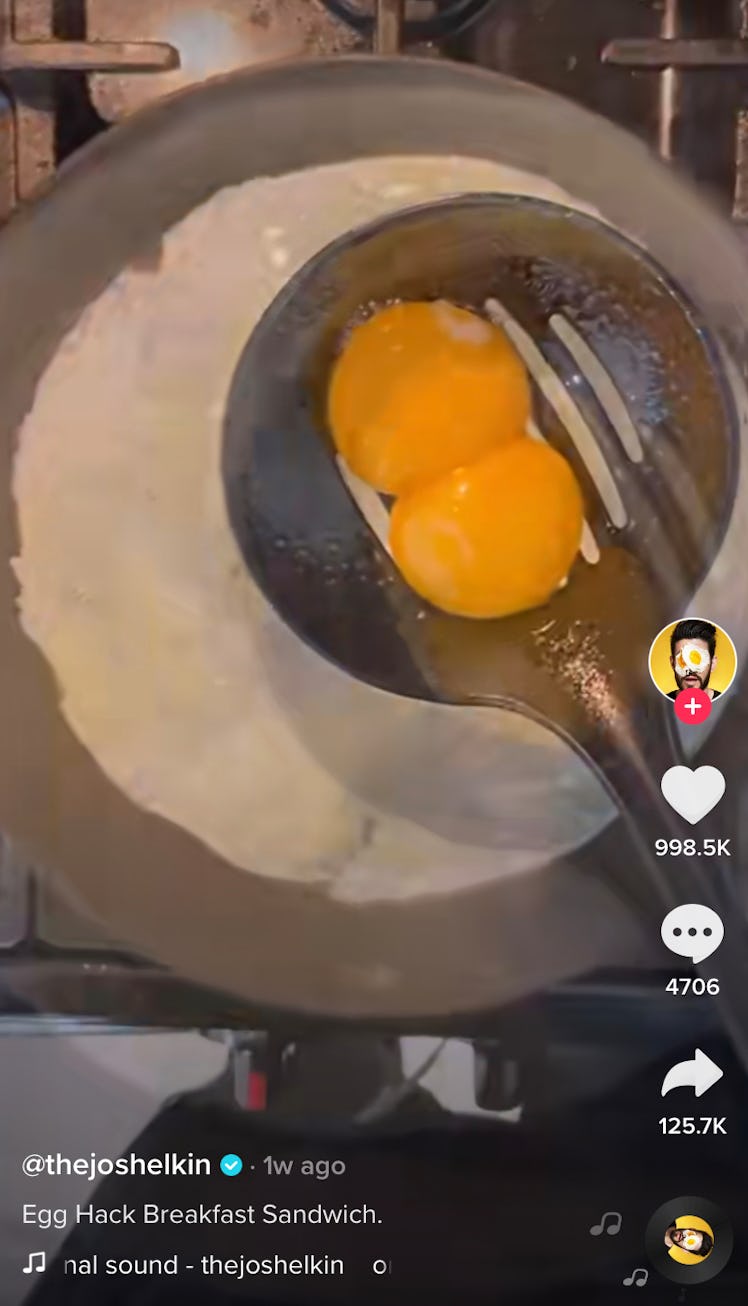 A home chef separates the egg whites from the yolks while making an egg hack breakfast sandwich for ...