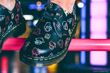 Dr. Martens x Hello Kitty 1461 boots being modeled in an arcade.