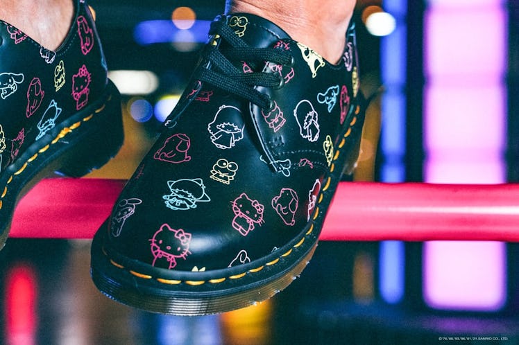 Dr. Martens x Hello Kitty 1461 boots being modeled in an arcade.