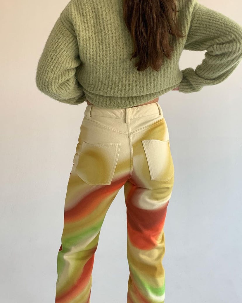 A young lady posing with colorful swirl pants