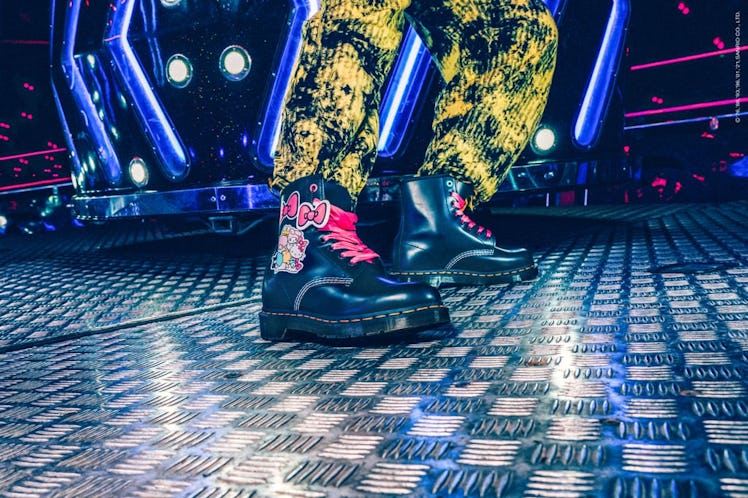 Dr. Martens x Hello Kitty Jadon boots being modeled in an arcade.