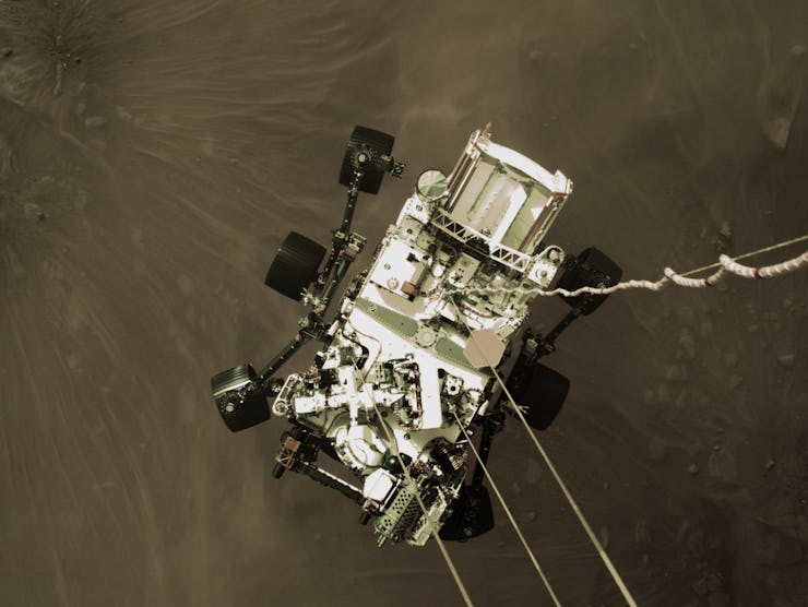 An image of the Perseverance rover as it descends to the surface of Mars.