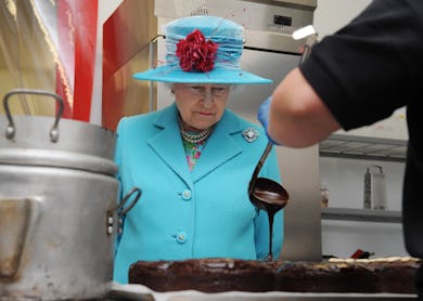 The queen watching a chocolate cake be made.