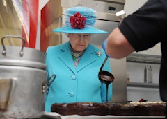 The queen watching a chocolate cake be made.