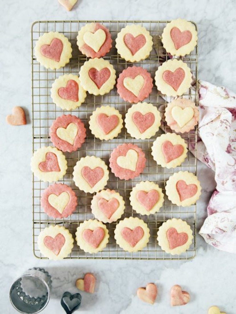 Cooling tray of pink and white sugar cookies with heart cutouts
