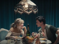 Sabrina Carpenter sits at a lavish dinner table with co-star Gavin Leatherwood in the "Skin" music v...