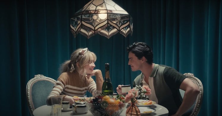 Sabrina Carpenter sits at a lavish dinner table with co-star Gavin Leatherwood in the "Skin" music v...