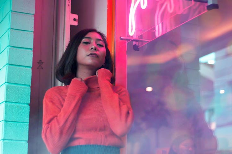 Portrait Of Beautiful Young Woman Standing By Window At Night