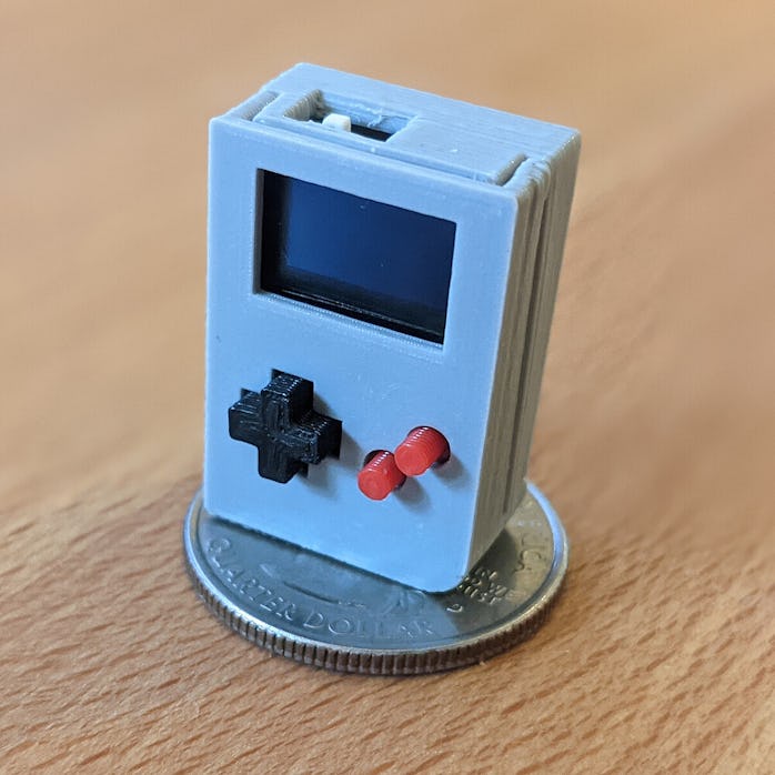 A tiny Game Boy clone is placed on an American quarter. If made to stand on the coin, the clone won'...