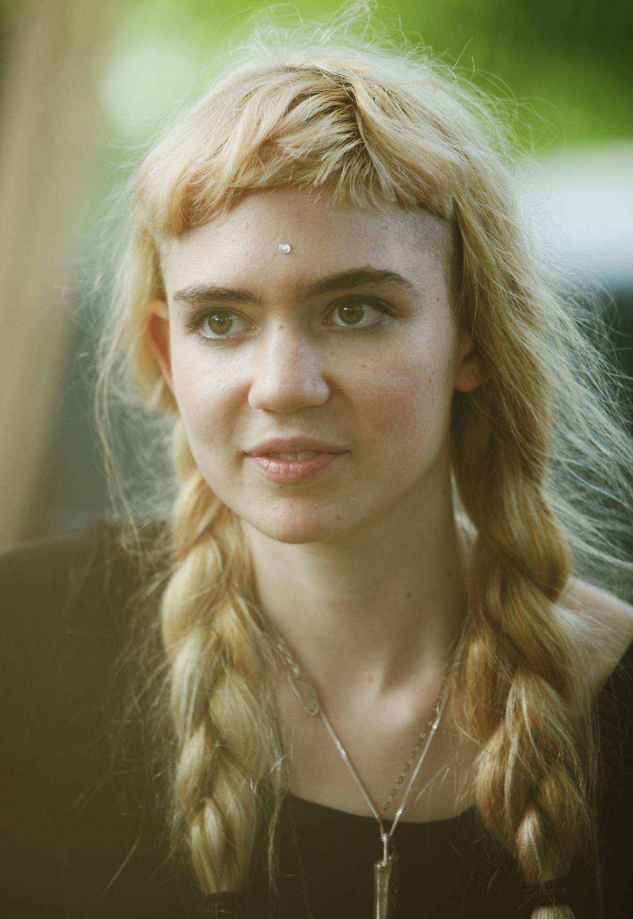 Grimes Beauty Evolution features blonde pigtails with baby bangs