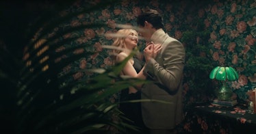 Sabrina Carpenter dances with Gavin Leatherwood behind a leafy plant in the "Skin" music video.