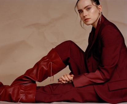 TZR cover star Daisy Ridley appears sitting down while wearing an all red Roksanda suit.