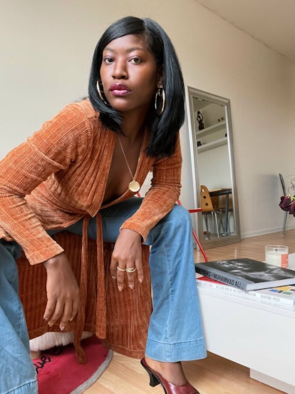Sade Mims in a light brown suede top and wide jeans 