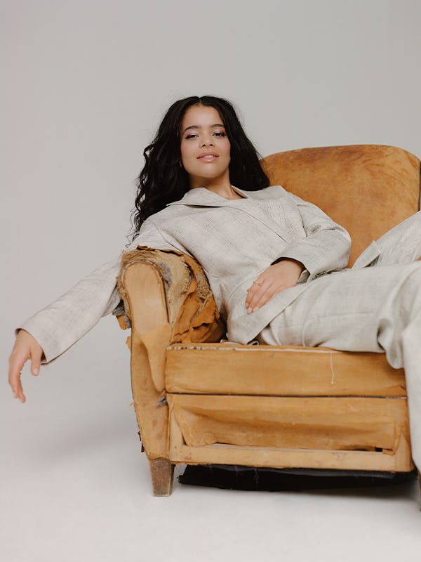 Lydia West trying to lie down in a chair while shooting in a studio for Bustle UK