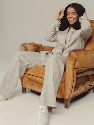 'It's A Sin' star Lydia West poses in a chair for Bustle UK.
