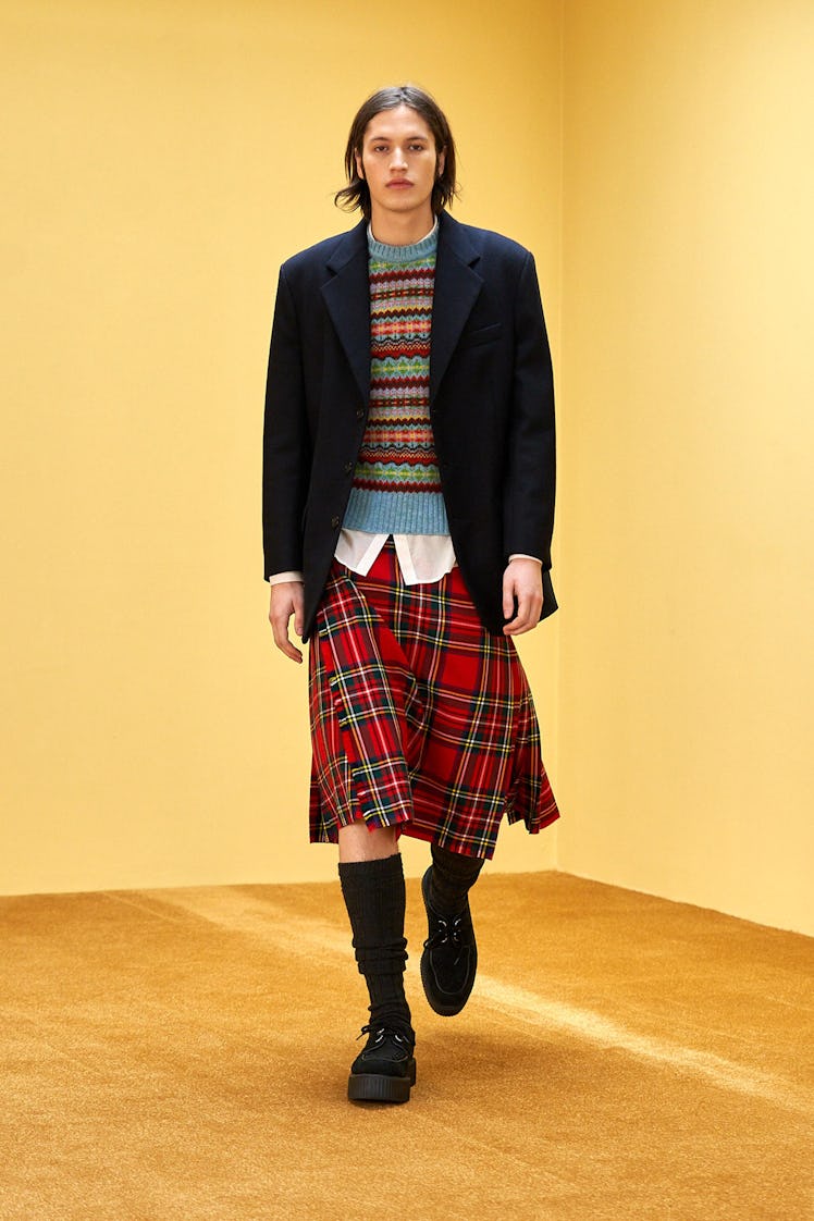A model in a Molly Goddard knit sweater, black blazer and a red check skirt at the London Fashion We...
