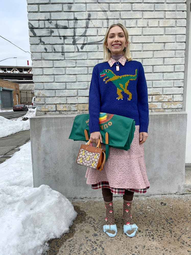 Tavi Gevinson in a Coach look book in a blue sweater with a dinosaur on it and a pink skirt 