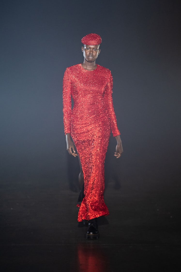 A model in an Art School red sequin dress and beret at the London Fashion Week