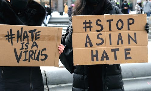 Two women hold signs saying #hateisavirus and #stopasianhate after the covid pandemic triggered a ri...