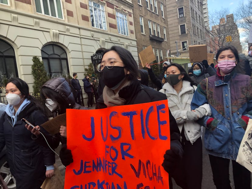A woman carrying a red "justice for Jennifer Vicha" hammer paper at anti-Asian racism protests in Ne...