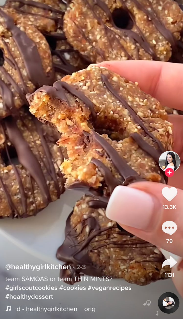 A woman holds up a vegan Samoa Girl Scout cookie for a copycat Girl Scout Cookie recipe on TikTok. 