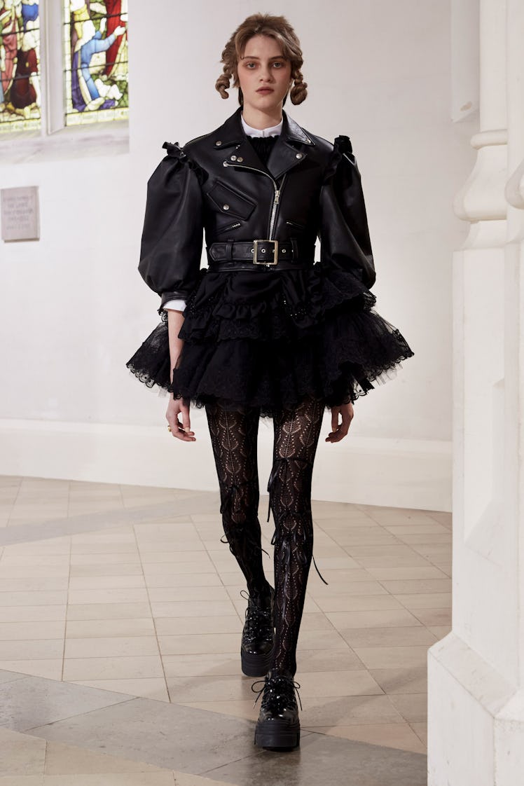 A model in a Simone Rocha black lace dress and black jacket at the London Fashion Week