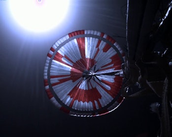 The Perseverance rover parachute seen above the rover itself as it is lowered down to the surface of Mars.