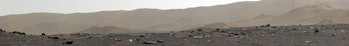 A detailed image of rocks strewn across the surface of Mars, with gradually sloping hills in the background.