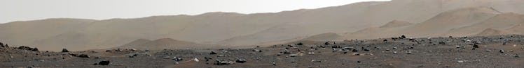 A detailed image of rocks strewn across the surface of Mars, with gradually sloping hills in the bac...