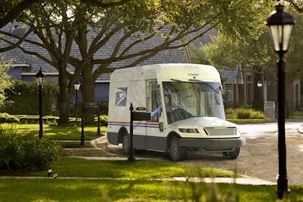 Next-generation USPS truck with large front window driving through a neighborhood.