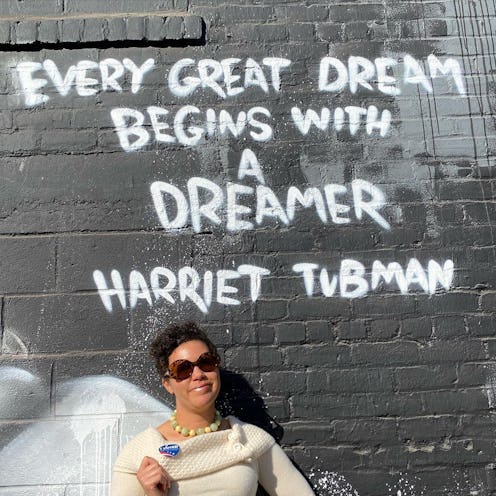 Image of Jessica Wilson in front of a wall with a Harriet Tubman quote, "every great dream begins wi...